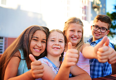 Buy stock photo Portrait of a group of young children showing thumbs up outside