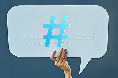 Buy stock photo Woman, hand and speech bubble with hashtag for comment, social media or feedback on a blue studio background. Closeup of female person with sign, symbol or icon for review, tag or notification alert