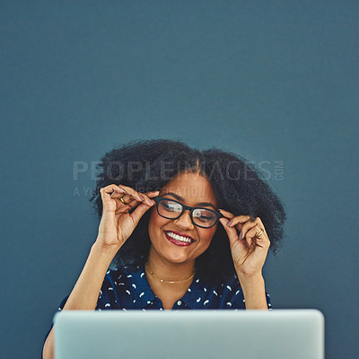 Buy stock photo Studio shot of a young woman using a laptop against a gray background