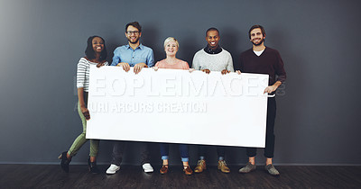 Buy stock photo Studio shot of a diverse group of people holding a blank placard against a gray background