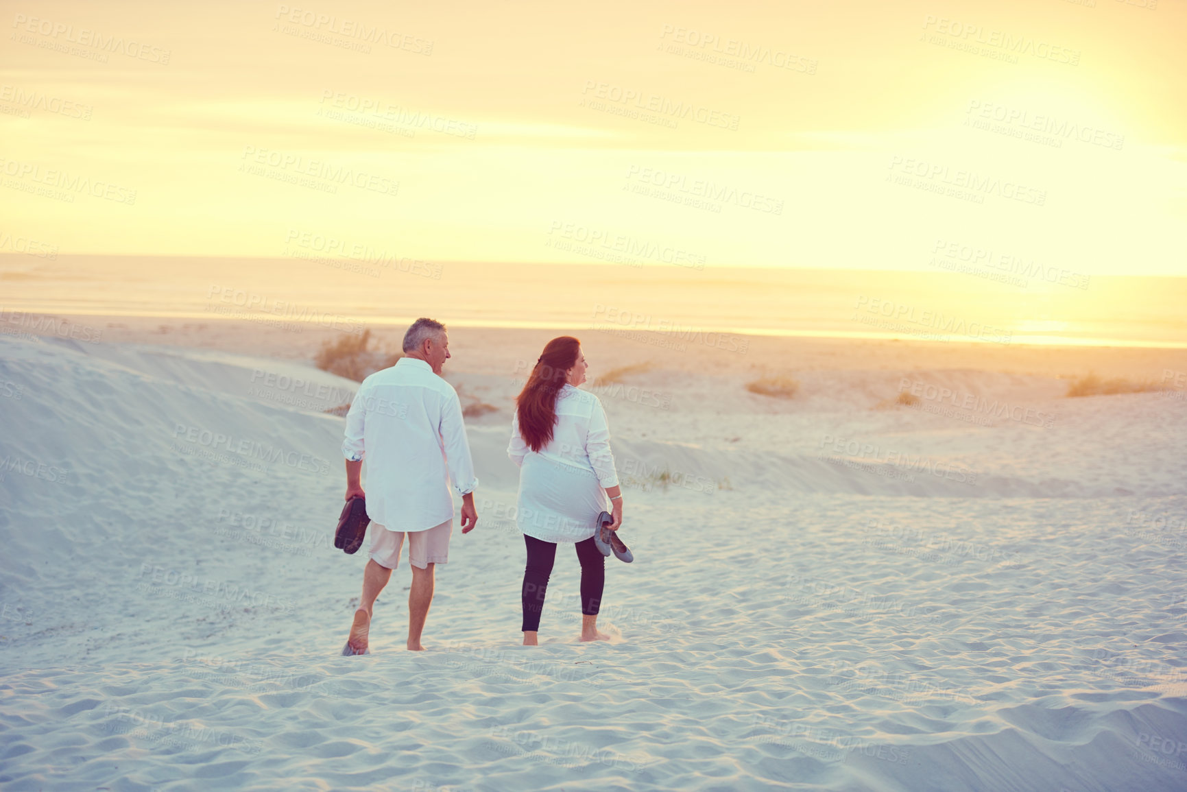 Buy stock photo Shot of a mature couple going for a relaxing walk on the beach