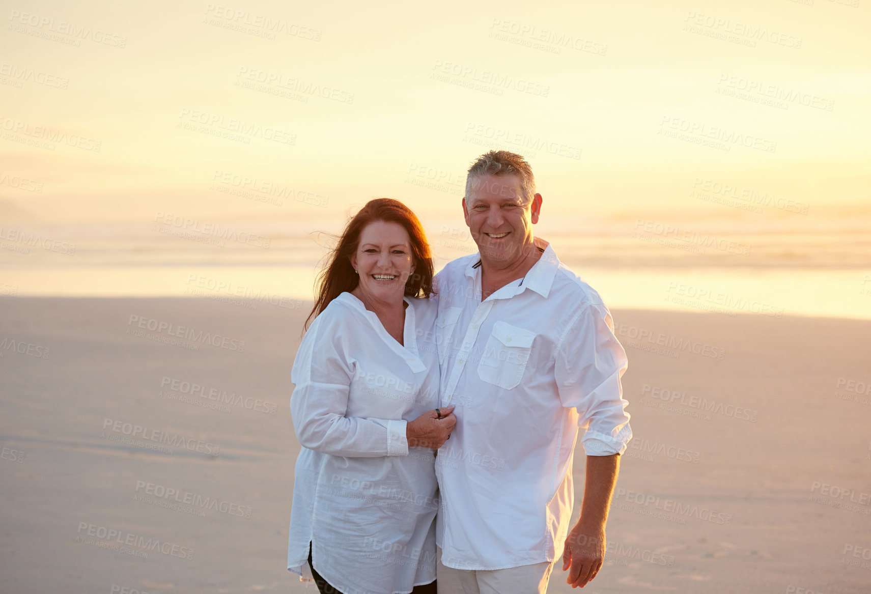 Buy stock photo Shot of mature people enjoying the sunset on the beach