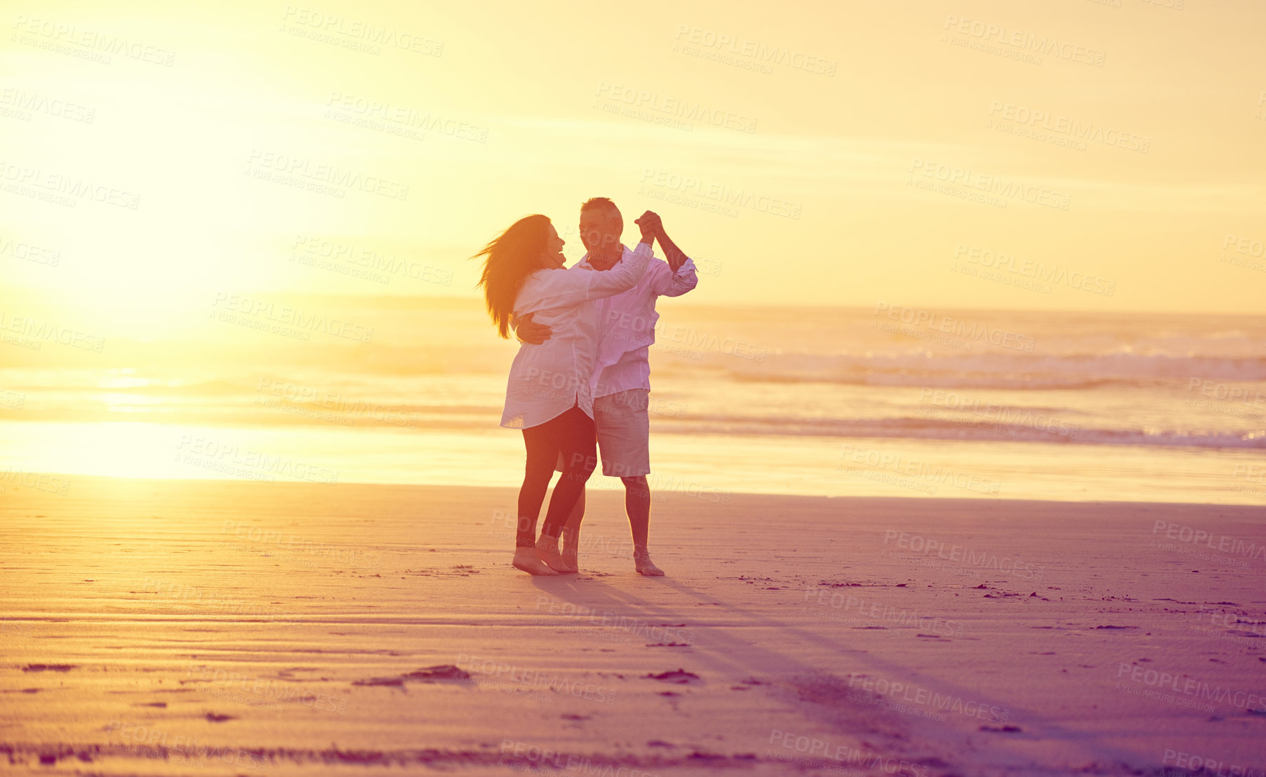 Buy stock photo Full length shot of an affectionate mature couple dancing on the beach at sunset