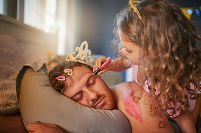 Buy stock photo Shot of an adorable little girl drawing with lipstick on her father's face while he sleeps