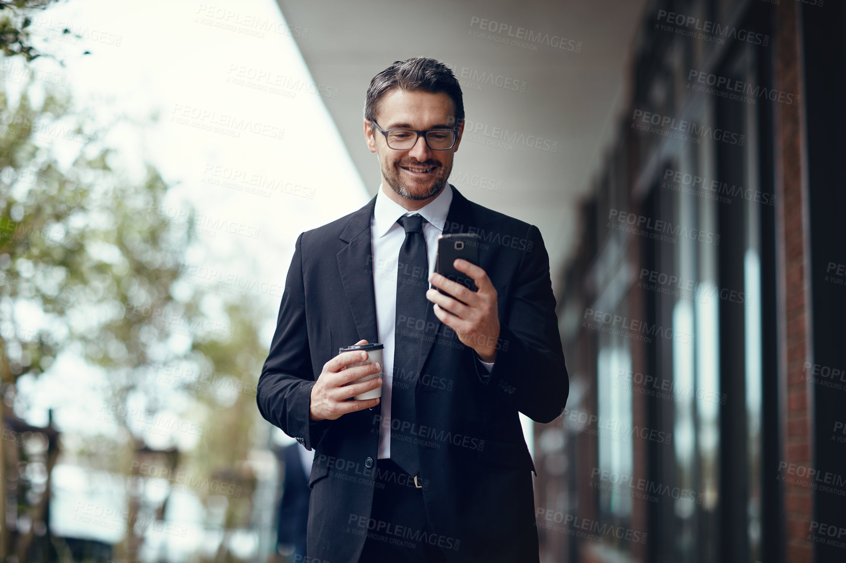 Buy stock photo Shot of a mature businessman texting on a cellphone while out in the city