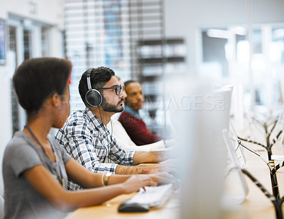 Buy stock photo Shot of a group of focused students working on computers  doing research for exams inside of a library