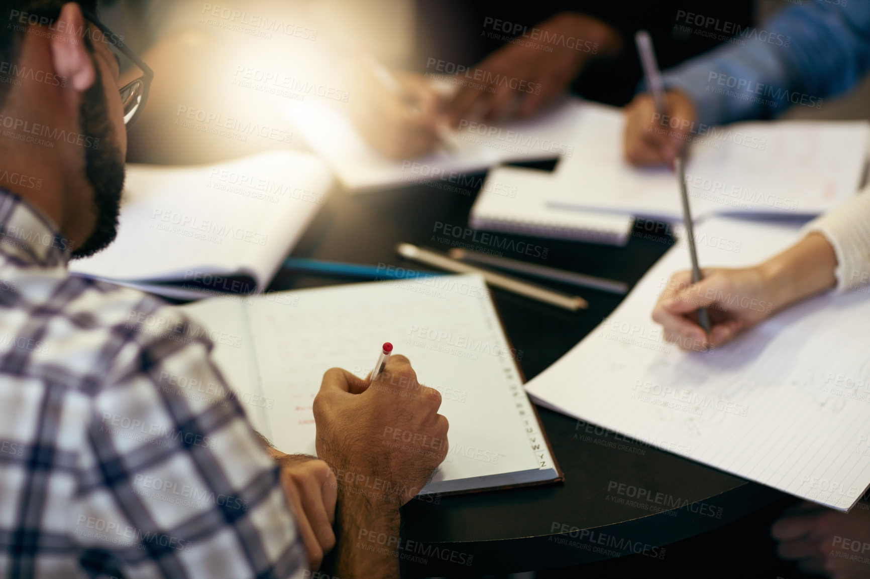 Buy stock photo Writing, notes and group of people in library together for university education, teamwork or school project research. College, men and women studying with notebook, support and planning for exam.