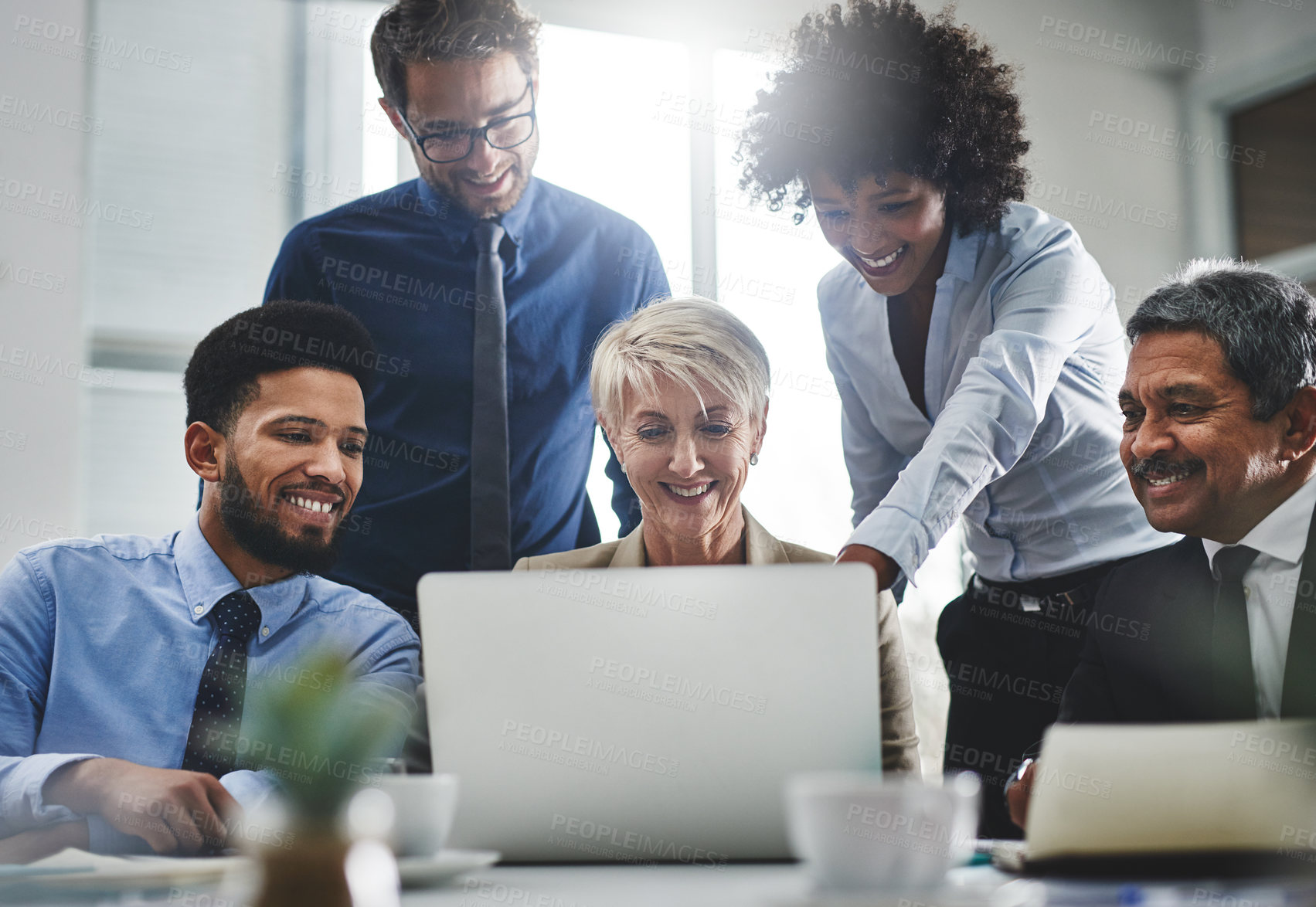 Buy stock photo Shot of a group of businesspeople working together on a laptop