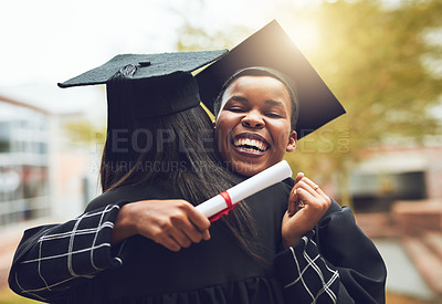 Buy stock photo Shot of two graduates embracing each other on graduation day