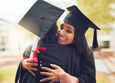 Buy stock photo Shot of two graduates embracing each other on graduation day
