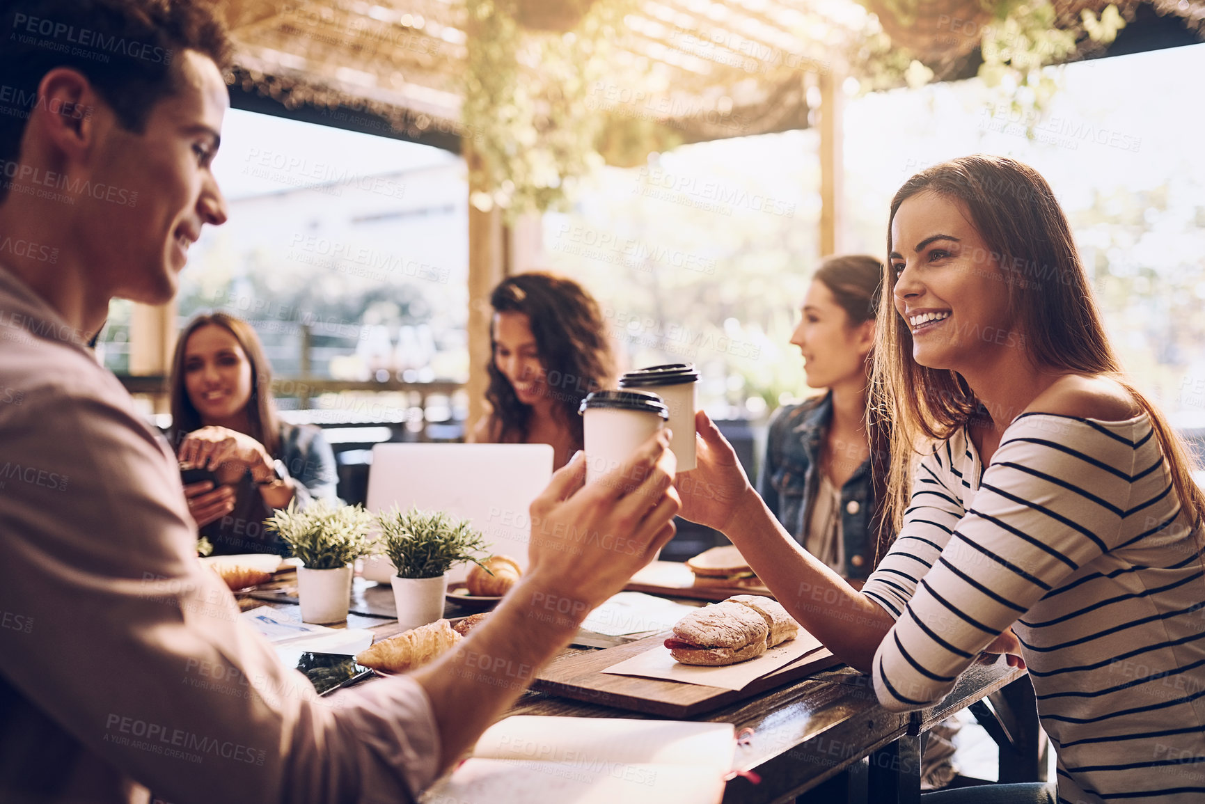 Buy stock photo Shot of friends toasting with cups of coffee while out for lunch