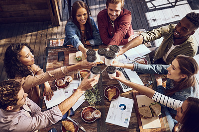 Buy stock photo Shot of a group of creative workers toasting with cups of coffee