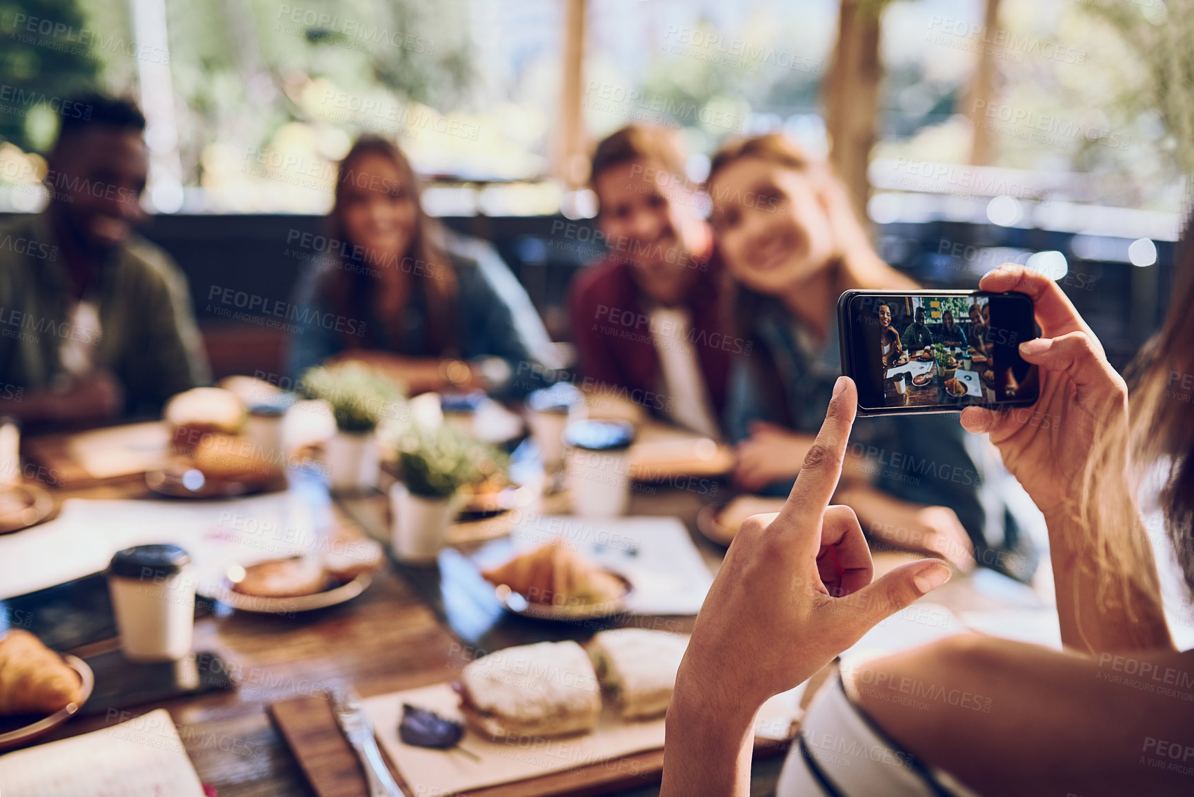 Buy stock photo Phone, friends and picture with lunch at restaurant for reunion memory, social media post and profile update. Group, people and hand with smartphone screen at cafe for dinner event, happy and relax