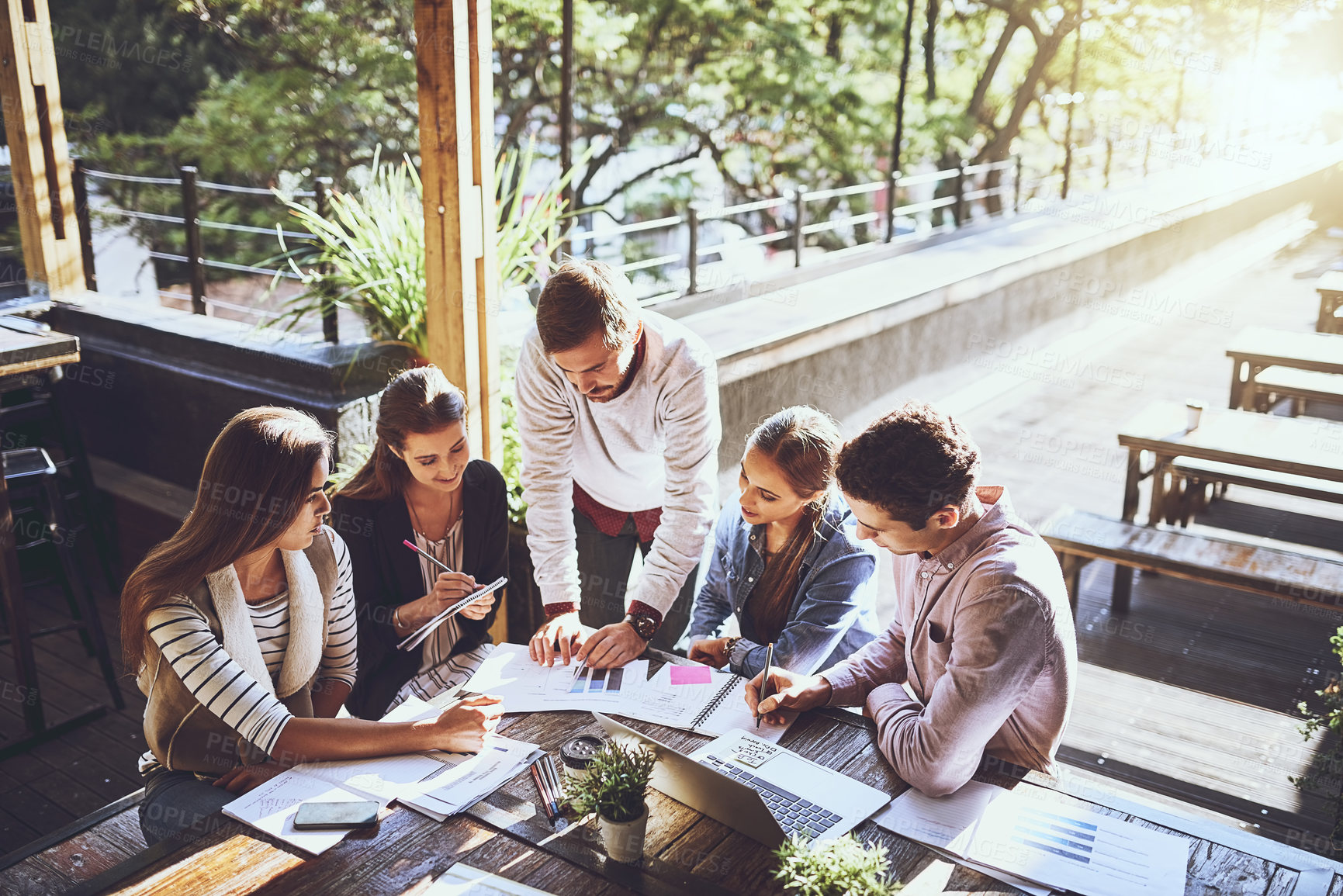 Buy stock photo Business, group and discussion in meeting, graph and ideas for project, outdoor and laptop in cafe. Planning, SEO and teamwork of people with stats, creative or typing of information and paperwork