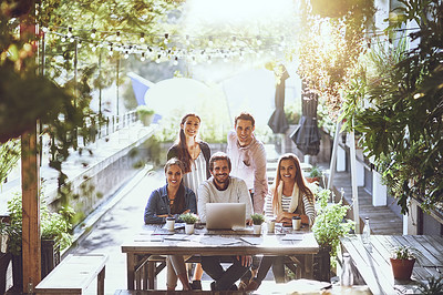 Buy stock photo Portrait of a team of colleagues using a laptop together during a meeting at an outdoor cafe