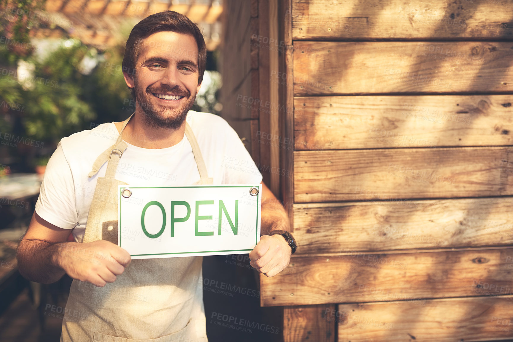 Buy stock photo Cropped shot of an unrecognizable business owner holding up a sign in the doorway of his coffee shop