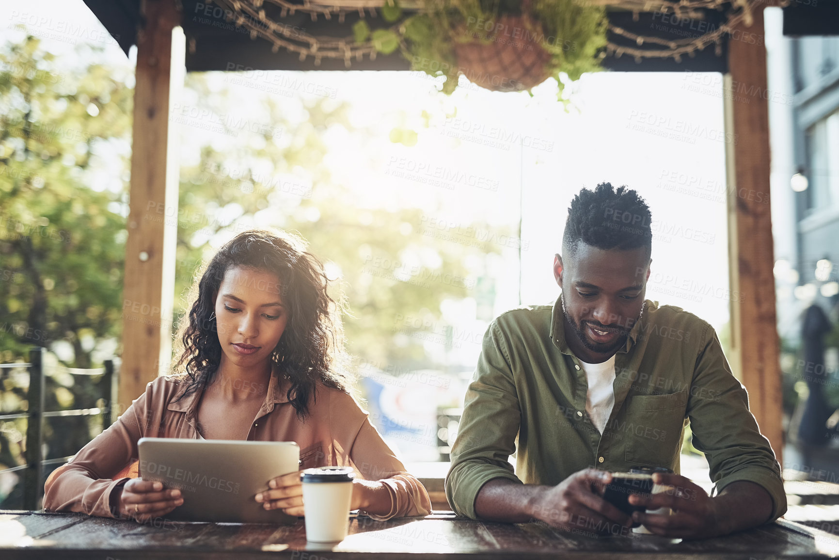 Buy stock photo Interracial, couple and digital with coffee at cafe for morning breakfast, social media and communication. People, tablet and cellphone for browsing website, typing email and restaurant bonding