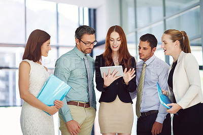 Buy stock photo Shot of colleagues using a tablet in a modern office