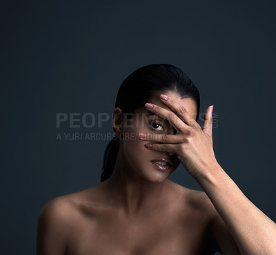 Buy stock photo Studio shot of a beautiful young woman posing against a dark background