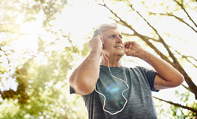 Buy stock photo Healthy, fit and active senior man listening to music while running, exercising and training outside from below. Happy, sporty and real mature male doing a cardio and endurance workout outdoors