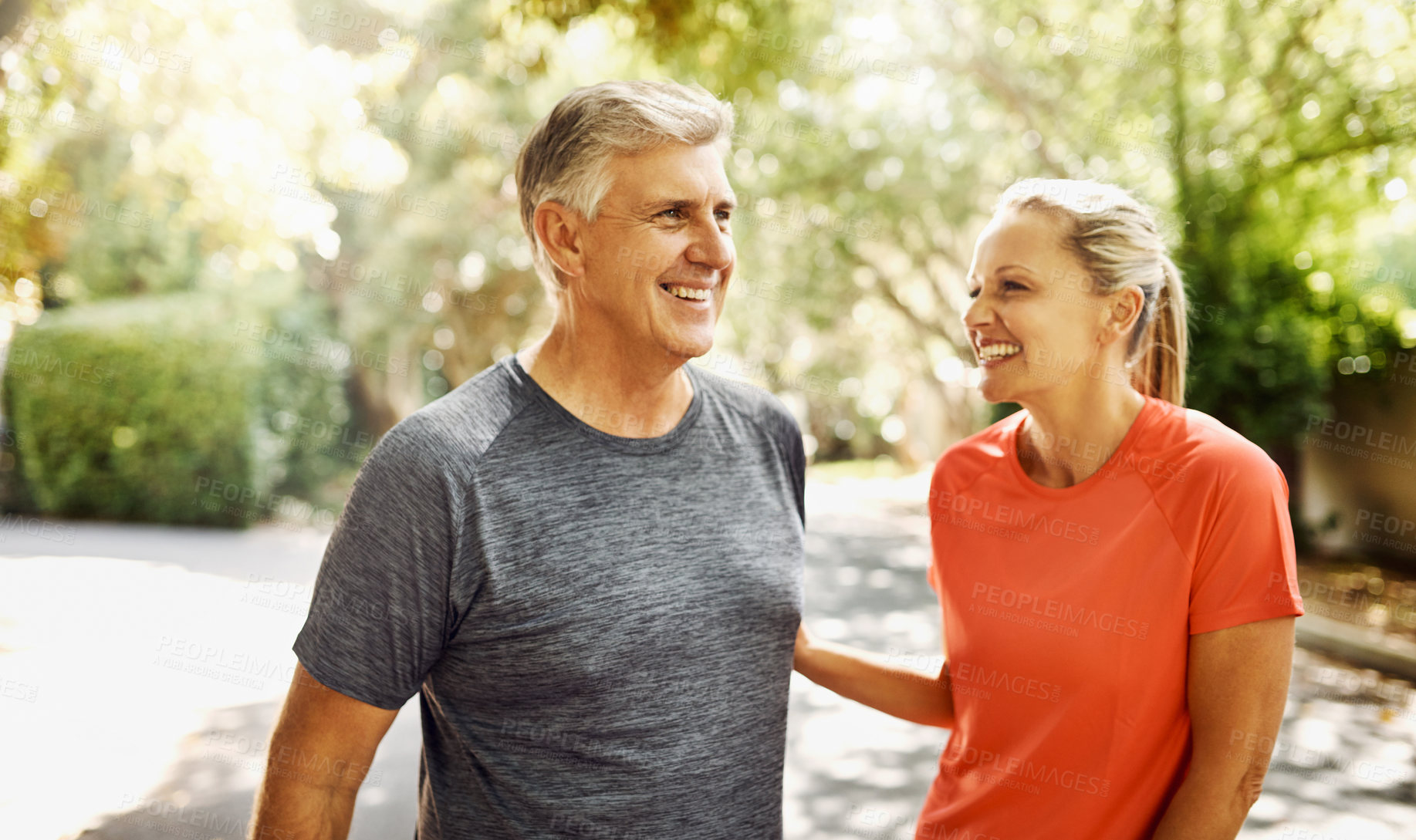 Buy stock photo Happy mature couple keeping active, fit and healthy while jogging, running or going for walk outdoors in nature environment. Laughing senior man and woman enjoying a break from workout or exercising