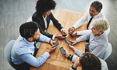 Buy stock photo Shot of a group of businesspeople using their cellphones in synchronicity