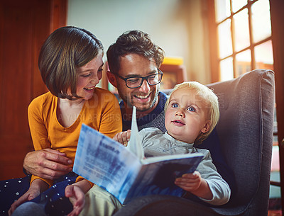 Buy stock photo Shot of father reading a book with his little son and daughter at home