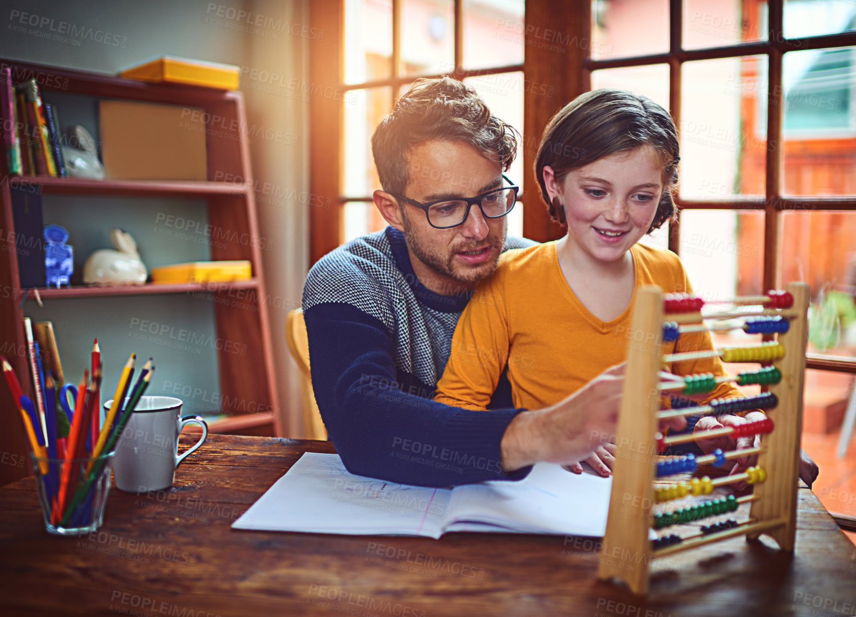 Buy stock photo Shot of a father helping his little daughter with her homework