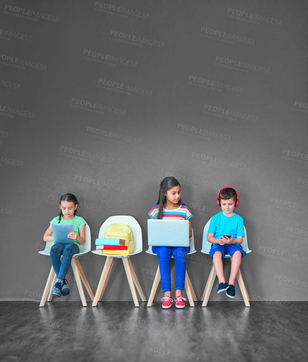 Buy stock photo Children, chair and technology for learning and education while online for research on internet. Kids or students against a grey mockup wall with laptop, tablet and phone in a waiting room with space