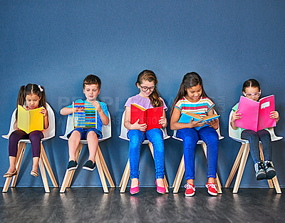 Buy stock photo Education, kids and students with books in studio for knowledge, development and studying for exam. Chair, row and children reading with paper for school, scholarship and learning for academic growth