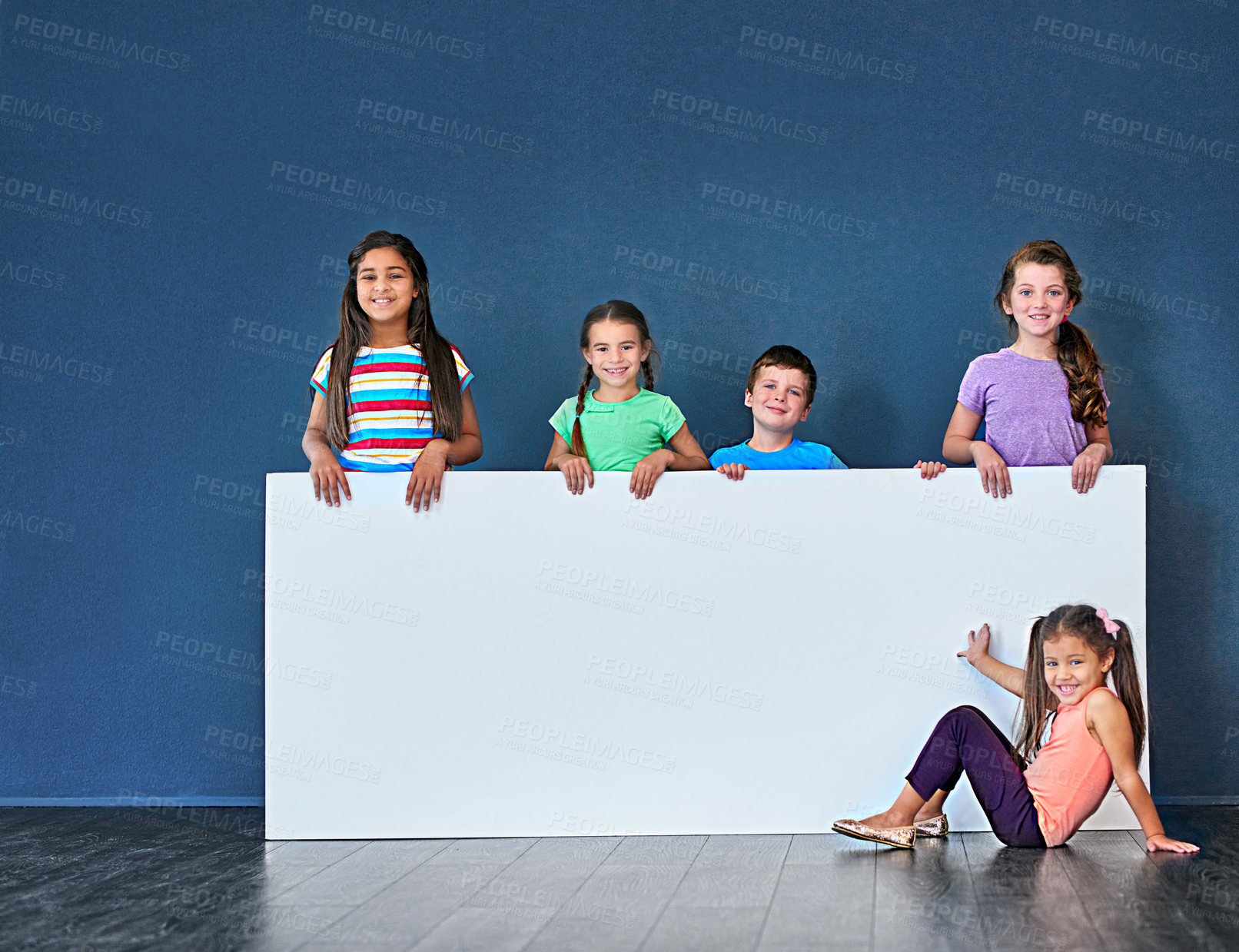 Buy stock photo Children, placard and portrait in studio for advertising, announcement and marketing with mockup space. People, smile and face on blue background for banner, branding and logo with promo information