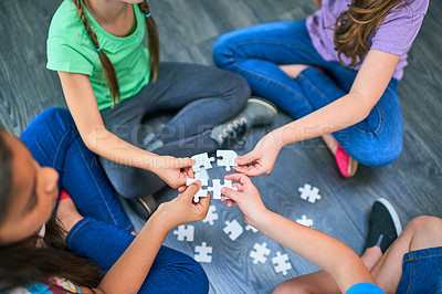 Buy stock photo Above, kids and game with puzzle for playing, cognitive development and solution skills by floor. Teamwork, children and solidarity with jigsaw for problem solving, support and friends for bonding