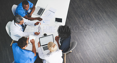 Buy stock photo Unity, teamwork and brainstorming by health care workers researching online while having a meeting in conference room. Overhead of doctors browsing the internet to help find cure or medical solution