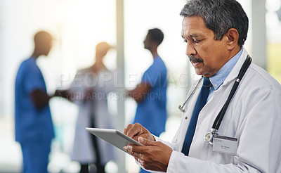Buy stock photo Doctor with tablet reading test results, browsing treatment options and researching medicine side effect in hospital. Mature medical professional and healthcare worker planning schedule on technology