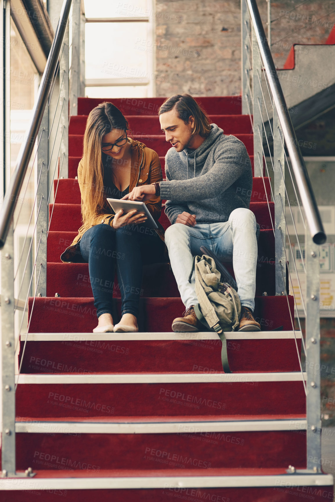 Buy stock photo Cropped shot of two young university students studying while sitting on a staircase on campus