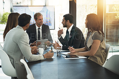Buy stock photo Shot of businesspeople using a digital tablet in a boardroom meeting