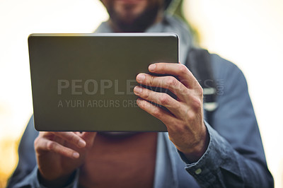Buy stock photo Cropped shot of an unrecognizable man using a tablet outdoors