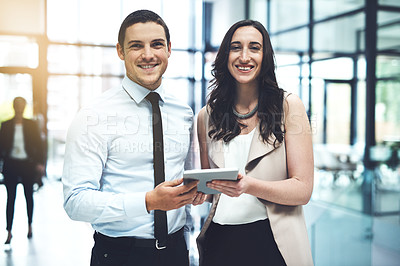 Buy stock photo Portrait of two businesspeople working on a digital tablet in a busy office