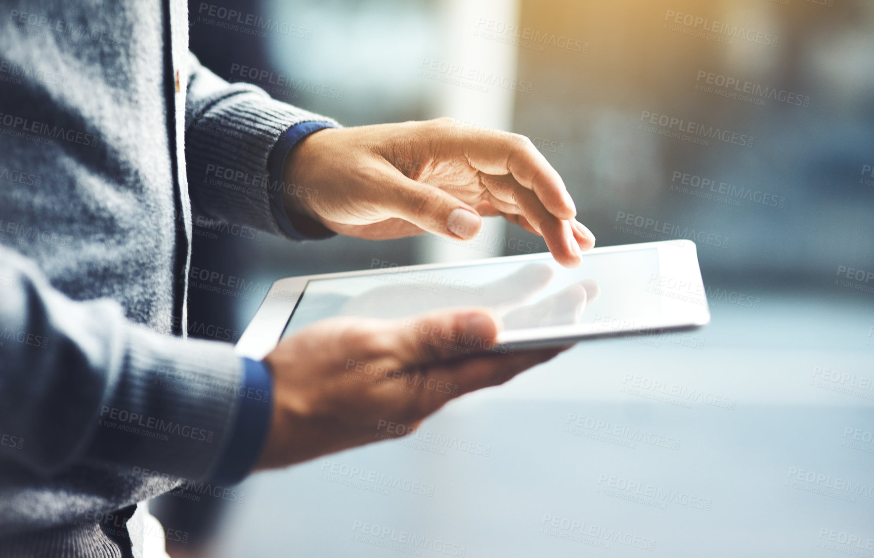 Buy stock photo Closeup shot of an unrecognisable businessman using a digital tablet in an office