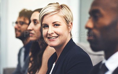 Buy stock photo Portrait of a young businesswoman sitting alongside her colleagues in an office