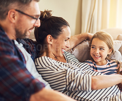 Buy stock photo Cropped shot of a happy young family of three relaxing on the sofa in their home