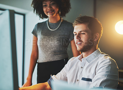Buy stock photo Shot of two young designers working together on a computer in the office