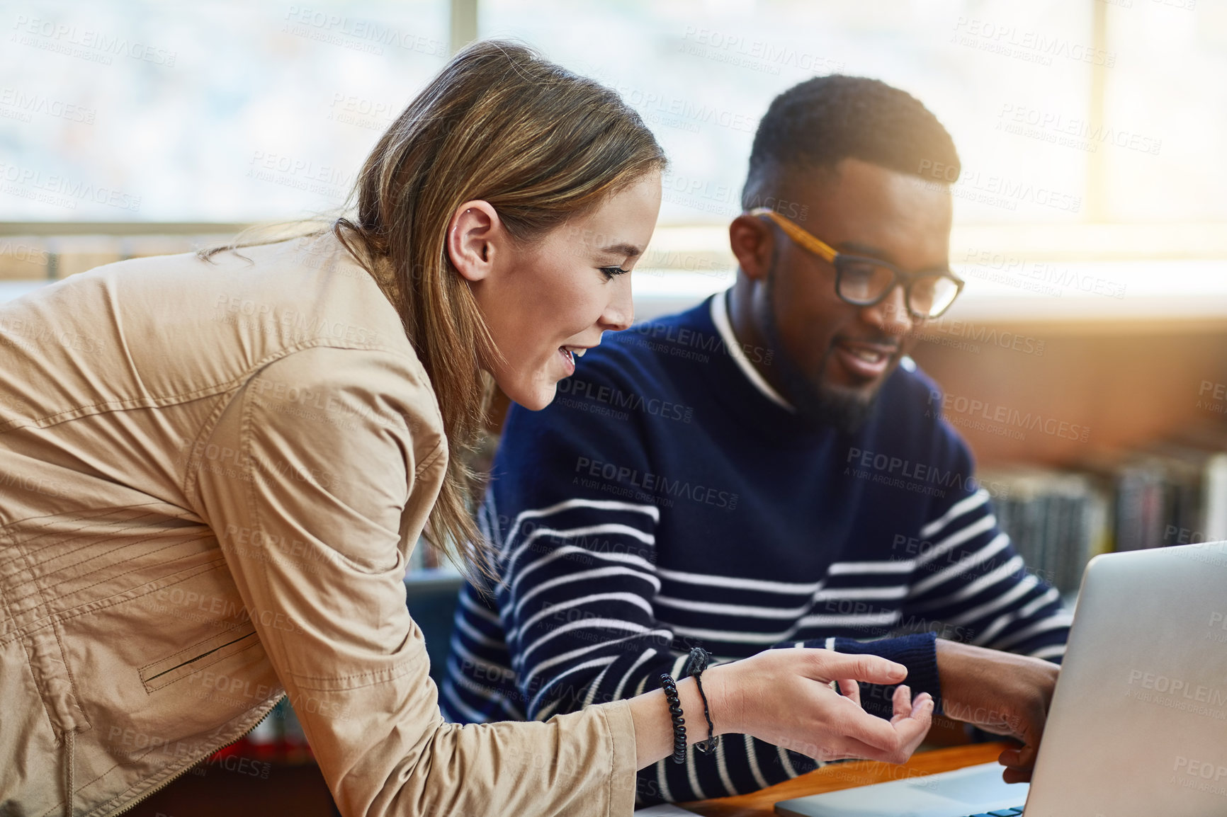 Buy stock photo Shot of two university students working together on a laptop at campus