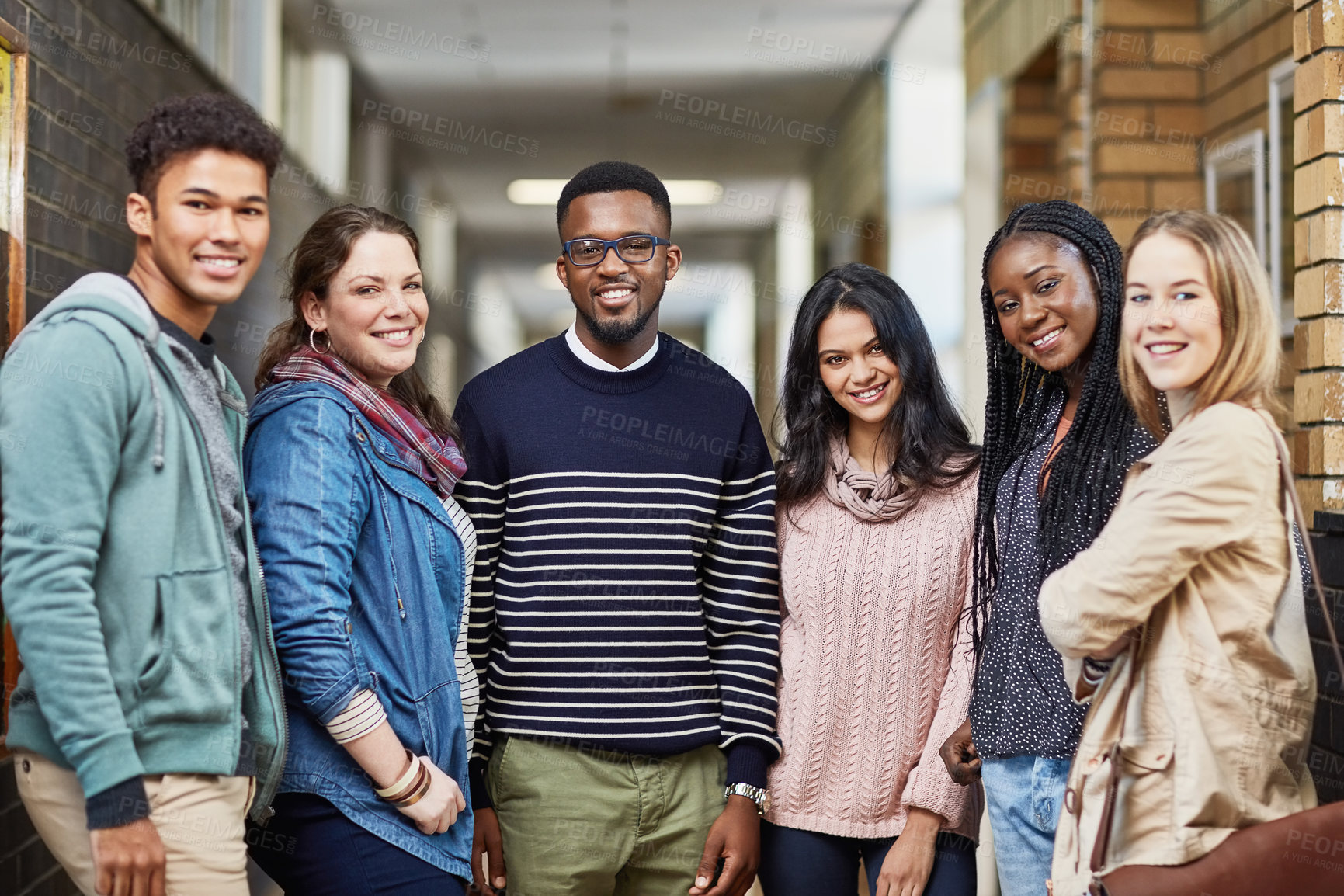 Buy stock photo Portrait of a group of university students standing together in a hallway at campus