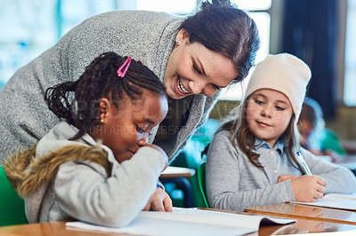 Buy stock photo Cropped shot of elementary school girls getting help from their teacher in the classroom