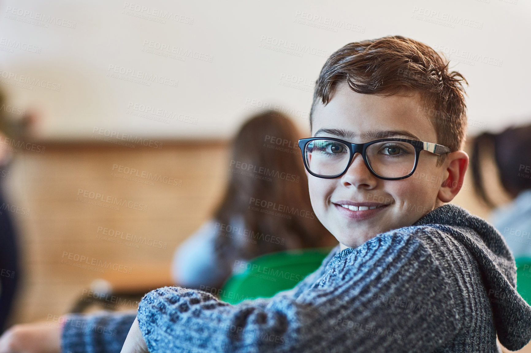 Buy stock photo Boy, classroom and portrait of face with glasses for education, learning and development in junior school. Male learner, smile or knowledge in academy for subject, growth or happiness for information