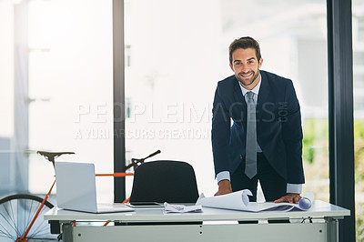 Buy stock photo Man, architect and portrait at desk with blue print in office for project planning, designing or property. Male person, face and smile for business entrepreneur with paperwork, workplace or report