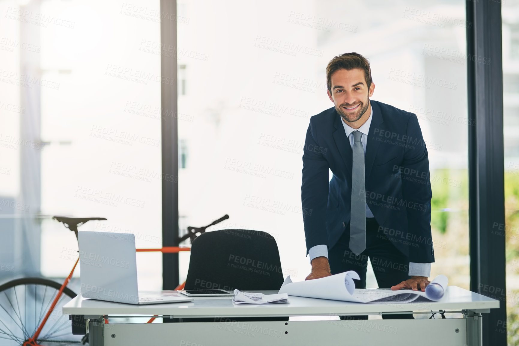 Buy stock photo Man, architect and portrait at desk with blue print in office for project planning, designing or property. Male person, face and smile for business entrepreneur with paperwork, workplace or report