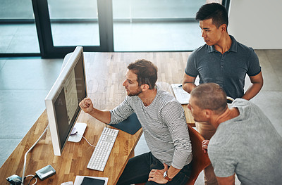 Buy stock photo High angle shot of three designers working together on a project in an office