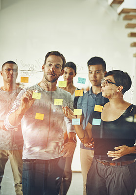 Buy stock photo Working, thinking and brainstorming office team using colorful notes to work together in a teamwork meeting. Group of modern employees writing on a board. Project collaboration of standing staff